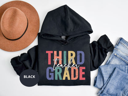 a black hoodie with the words third grade printed on it