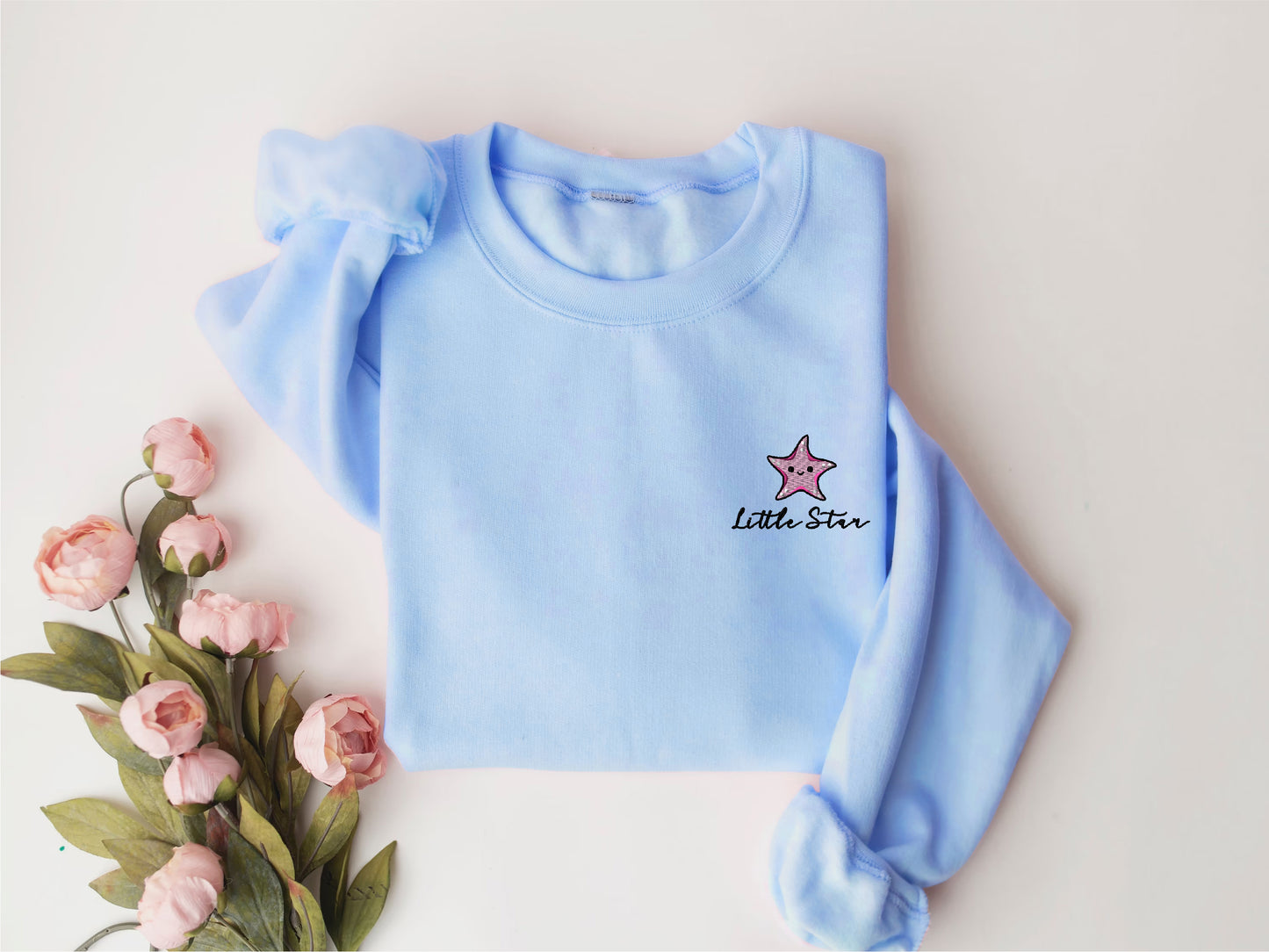 a blue sweater with a star embroidered on it