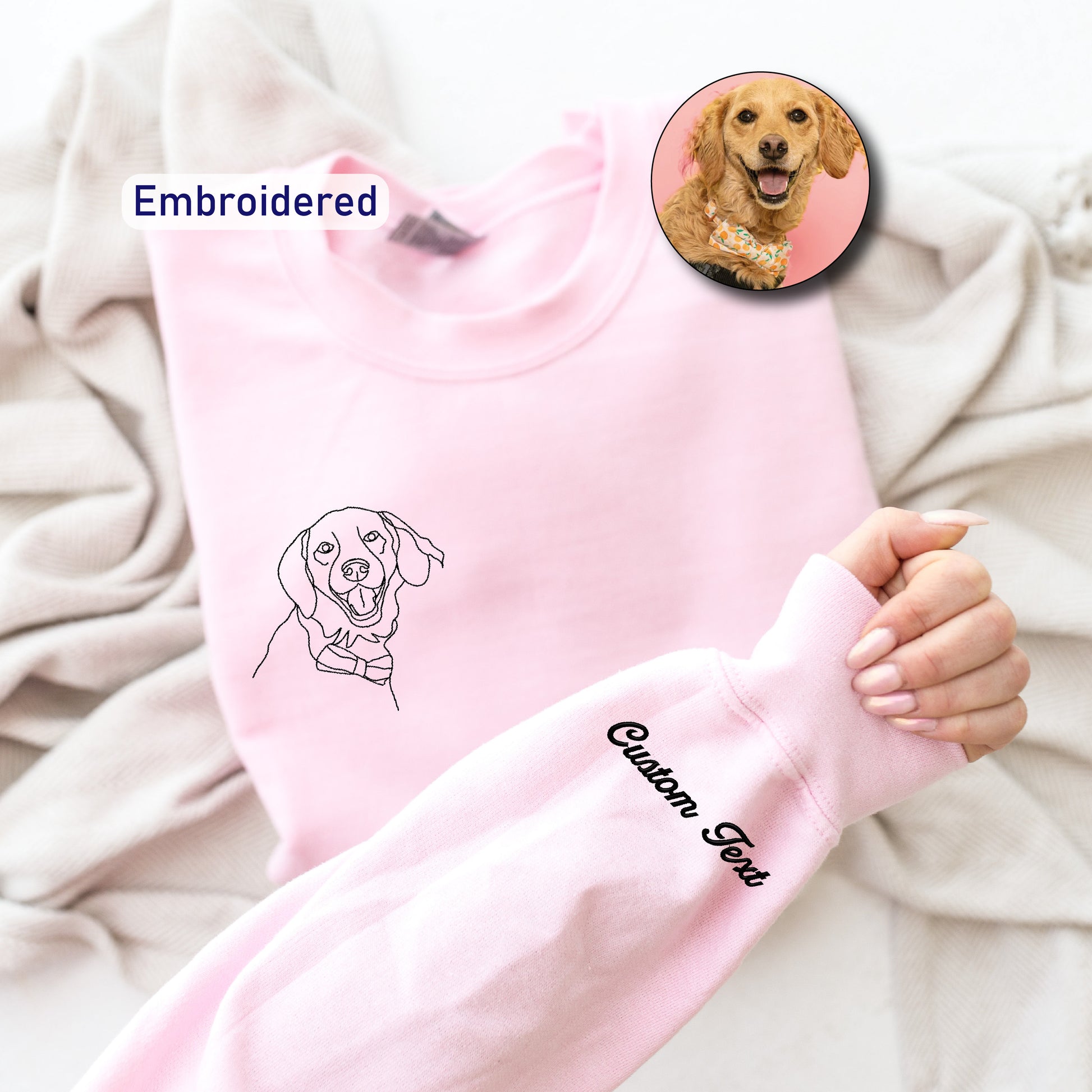 a person holding a pink sweater with a picture of a dog on it