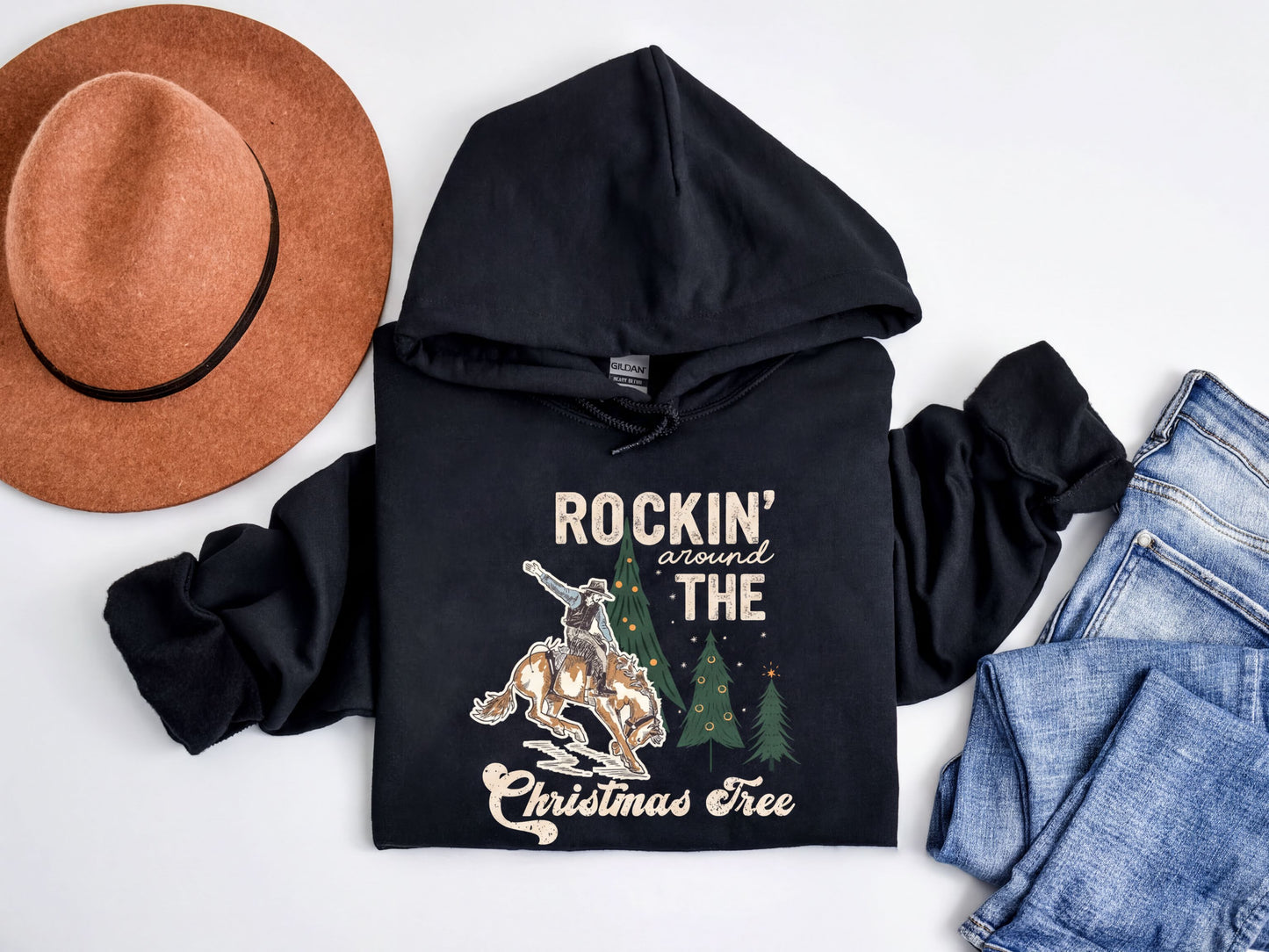 A black hoodie with a graphic design, a brown hat, and a pair of jeans are arranged on a white background.