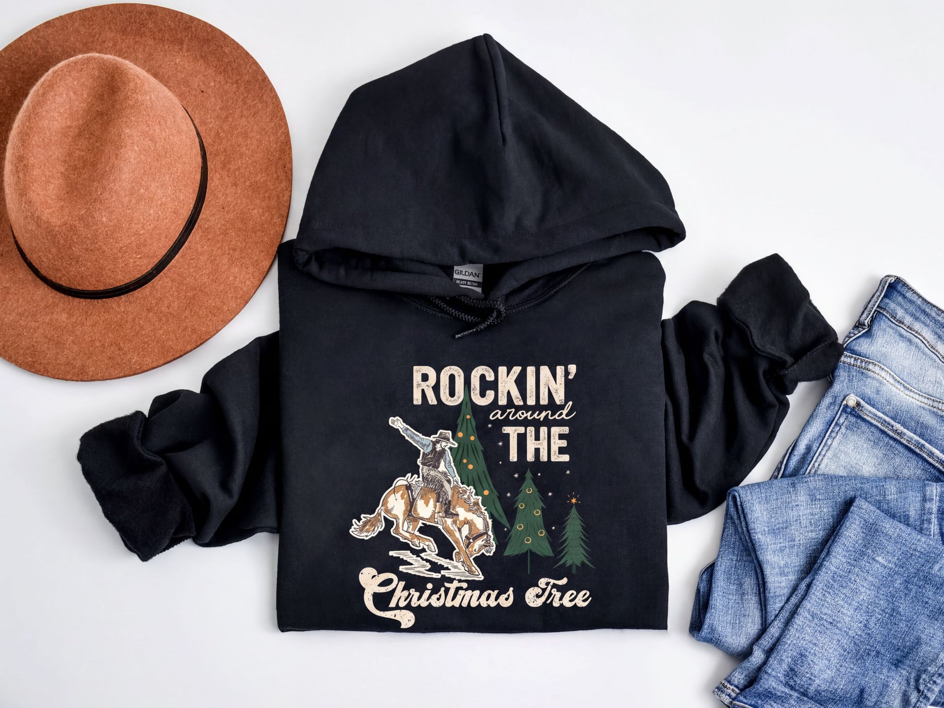 A black hoodie with a graphic design, a brown hat, and a pair of jeans are arranged on a white background.