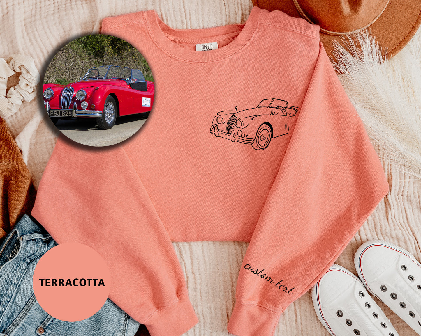 a pink sweater with a picture of a car on it