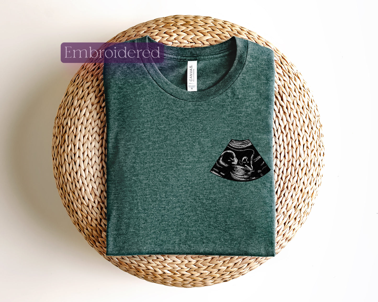 a green t - shirt with a black owl pocket on it