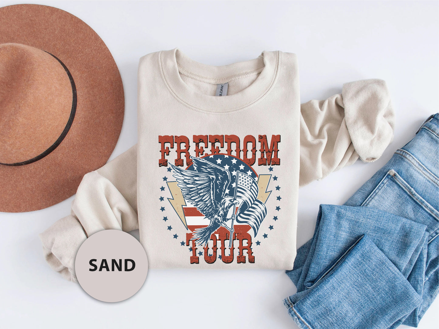 a casual outfit consisting of a white t-shirt with a graphic design, a brown hat, and a pair of blue jeans.