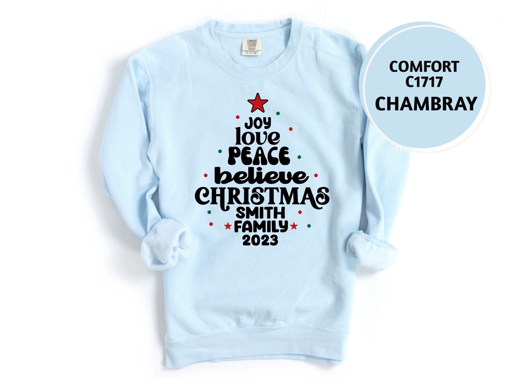 A light blue sweatshirt with a Christmas tree design and text printed on it.