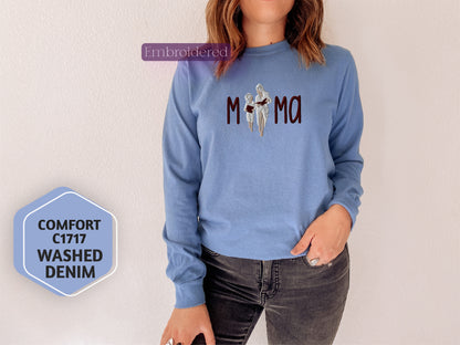 a woman wearing a blue sweatshirt with the word mom printed on it