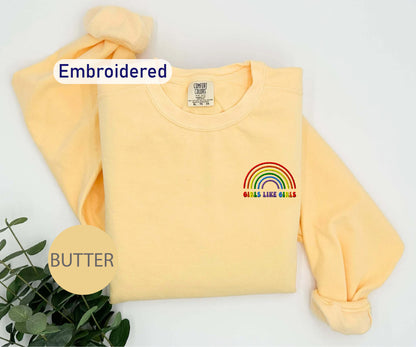 a yellow sweatshirt with a rainbow embroidered on it