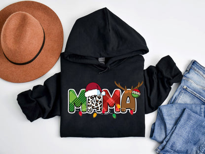 A black hoodie with a colorful Christmas-themed design, a brown fedora, and a pair of jeans are laid out on a white background.