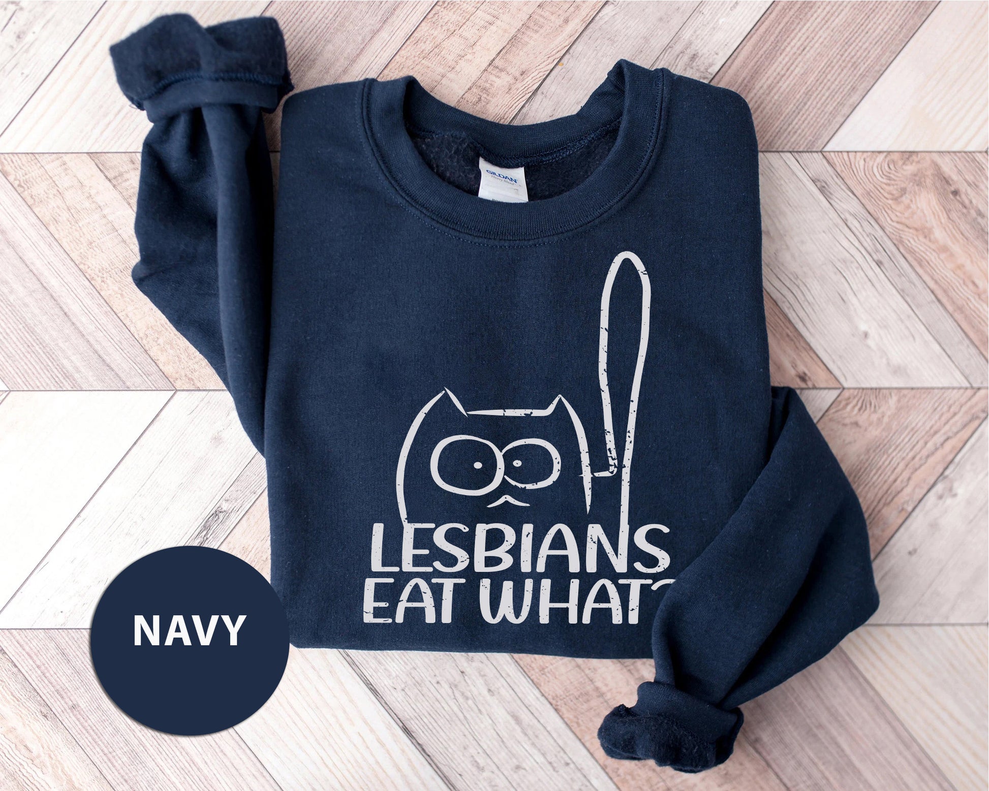 a navy sweatshirt with an image of a cat that says lesbians eat what