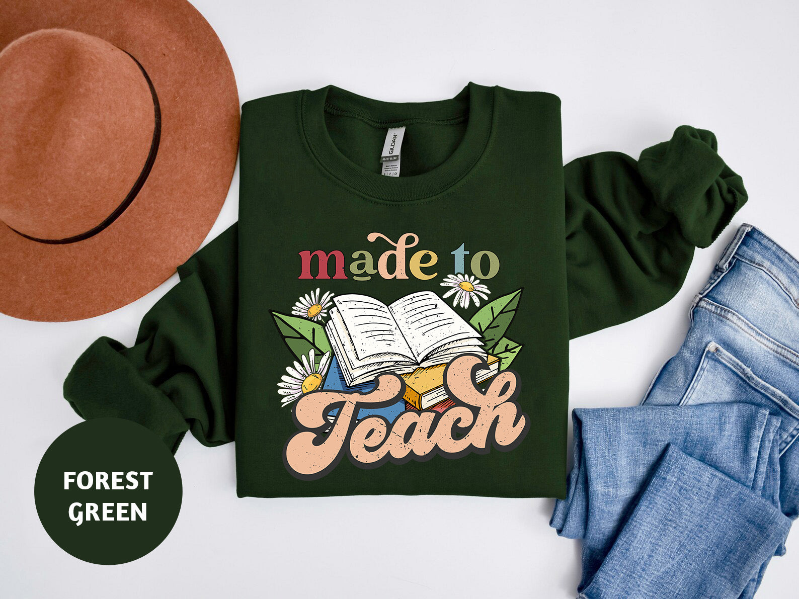 a green shirt that says made to teach next to a hat and jeans