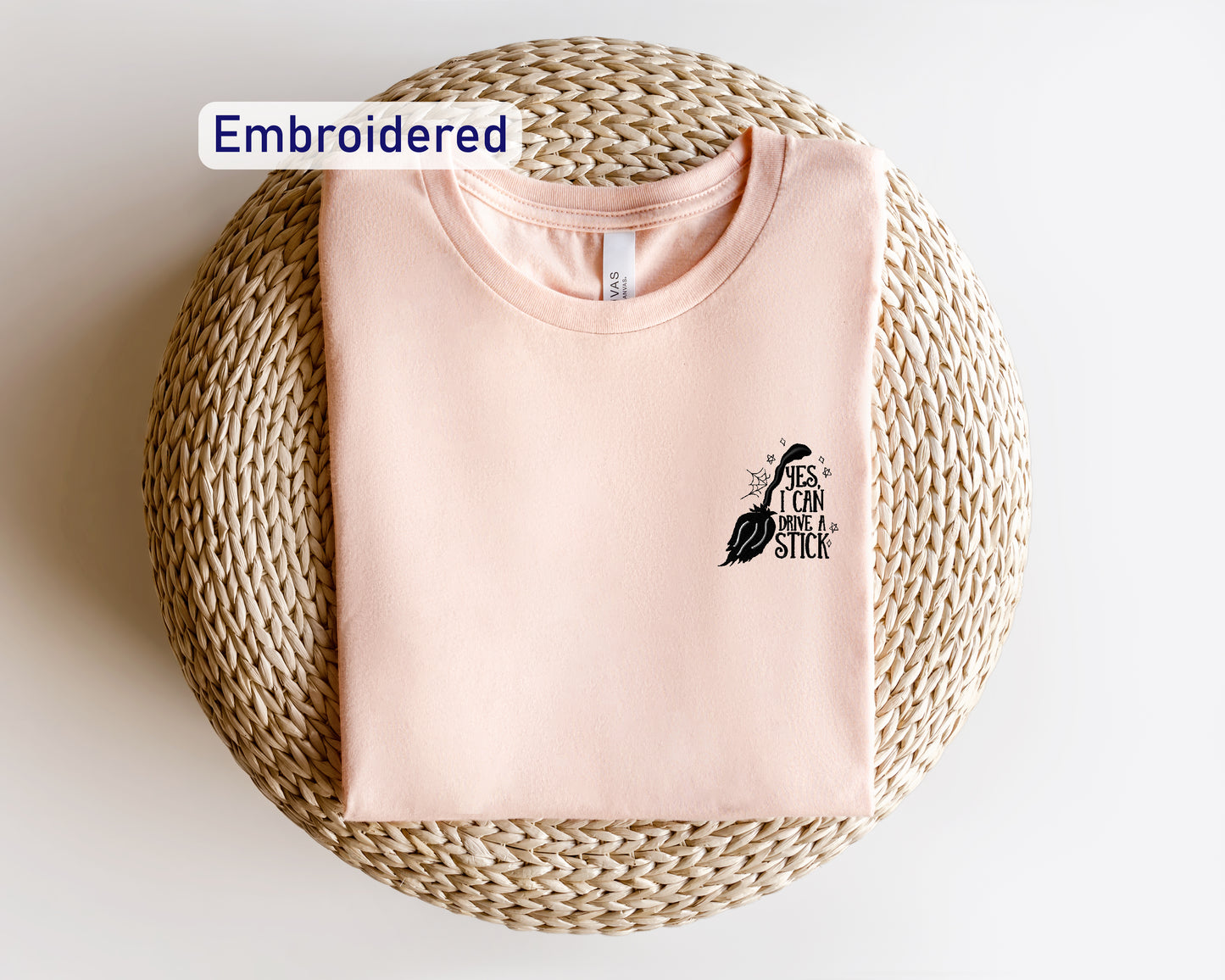 a pink t - shirt with a bird embroidered on it