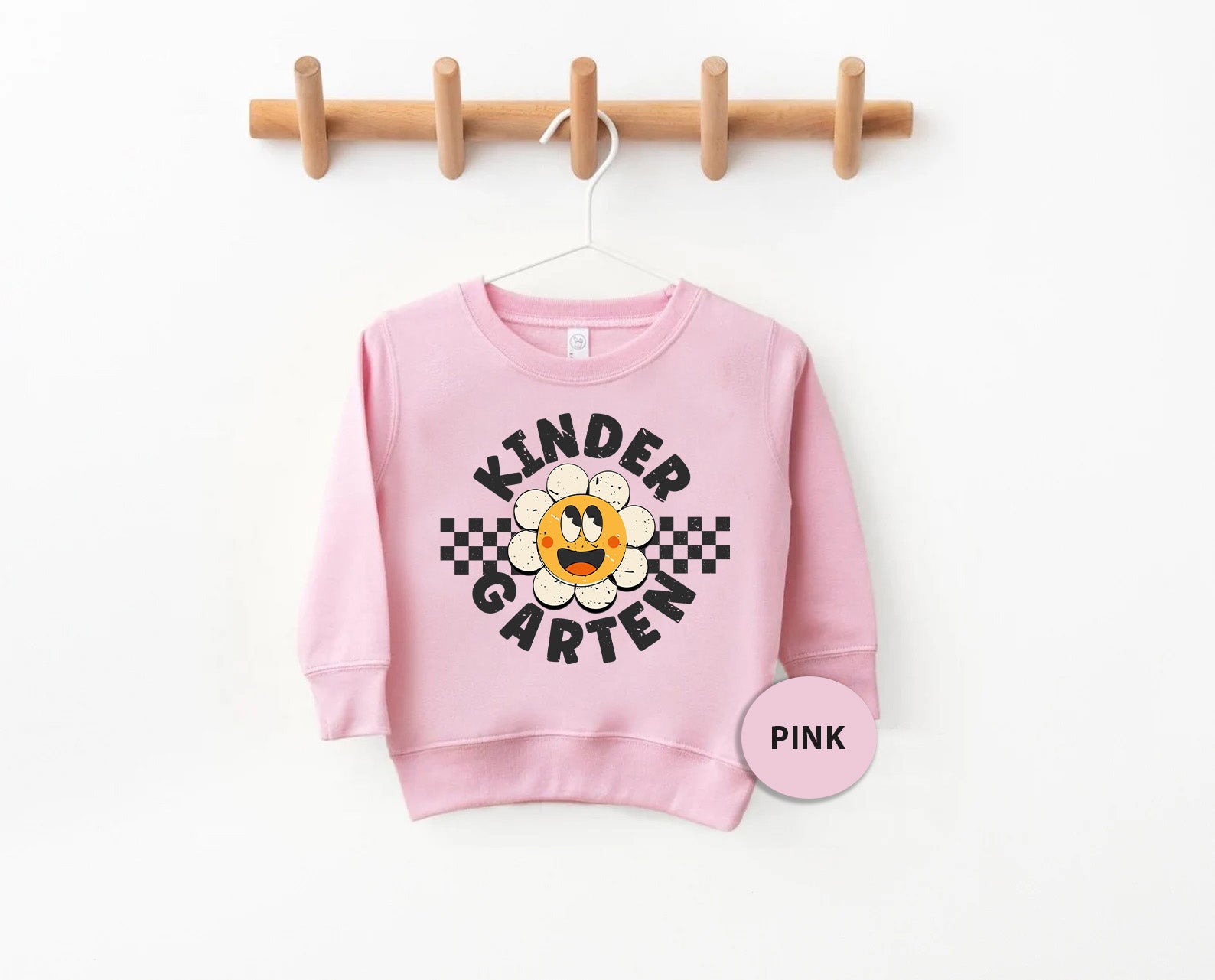 a pink sweatshirt hanging on a clothes rack