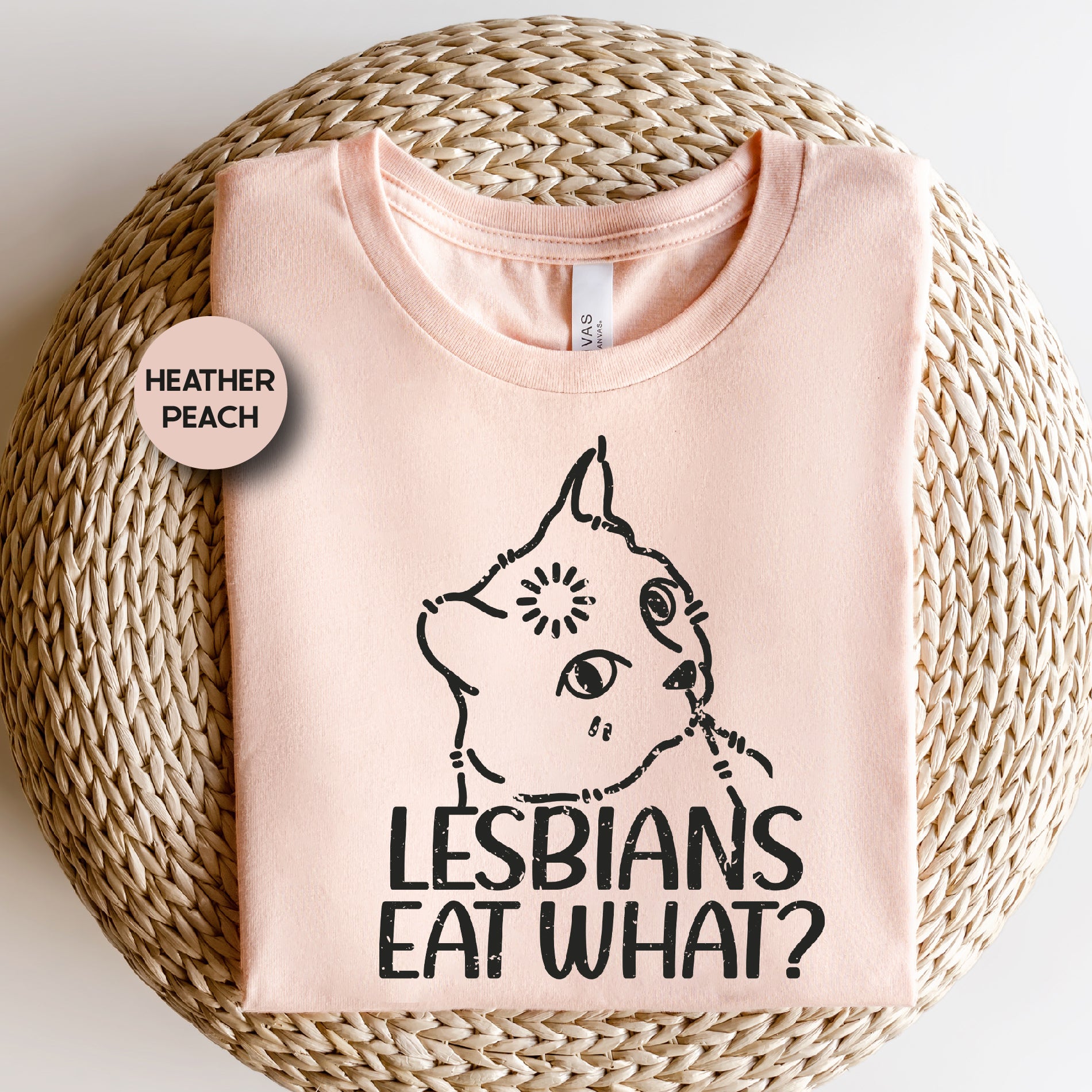 a pink t - shirt with a cat saying lesbians eat what?