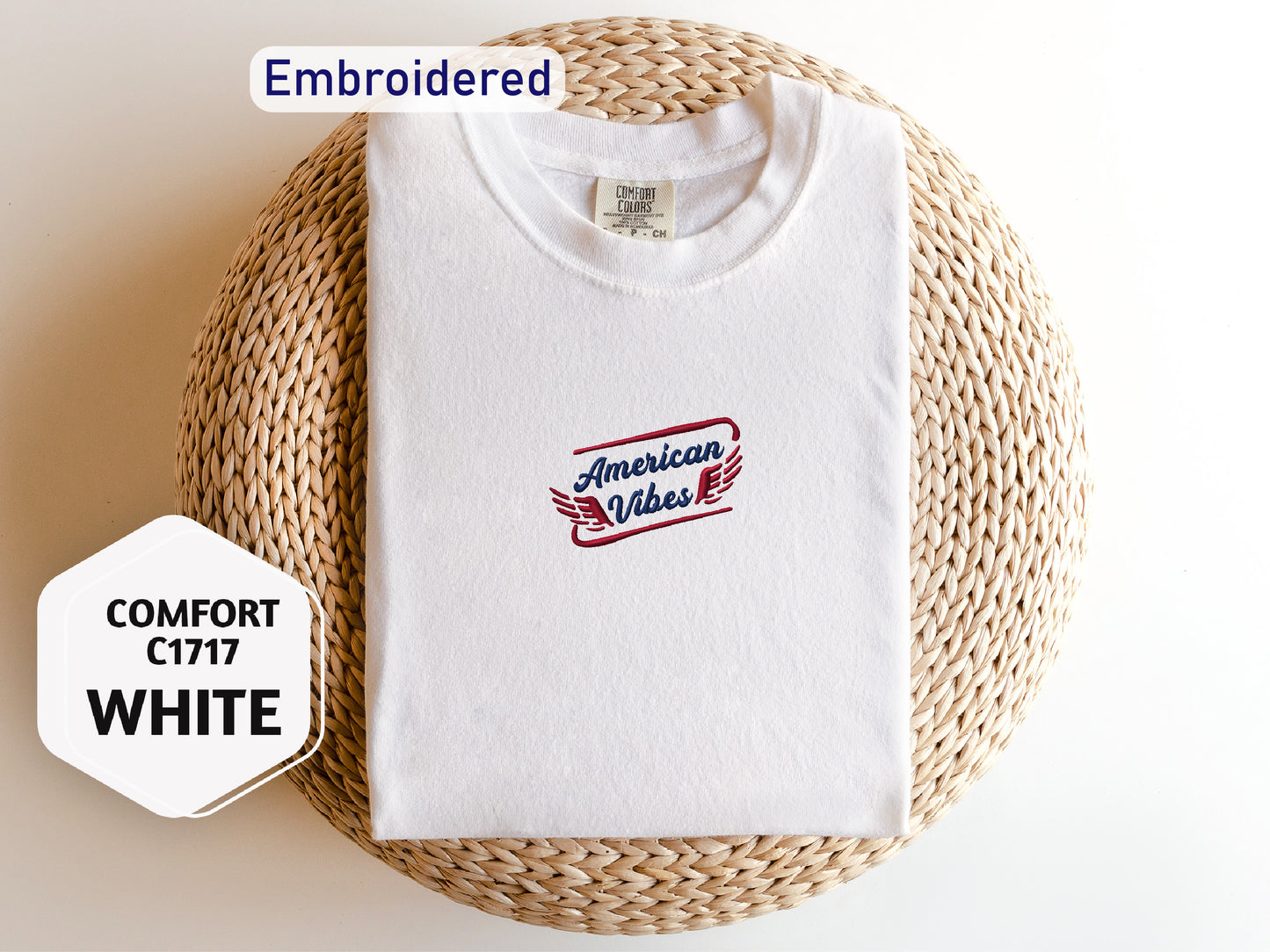 a white t-shirt with a red and blue logo, laid out on a woven basket or mat.
