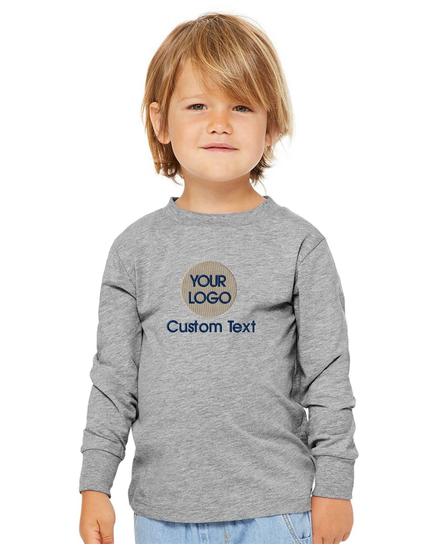 a little boy wearing a gray shirt with a logo on it