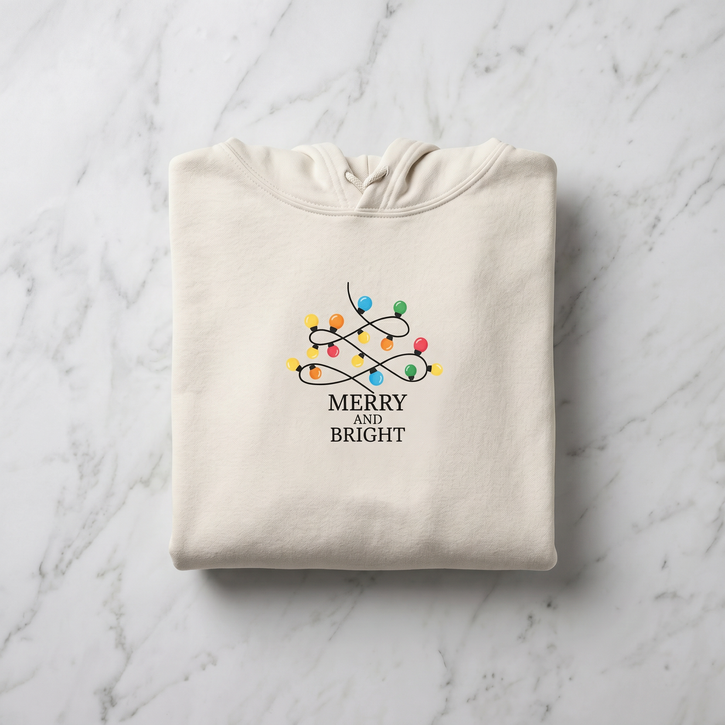 A beige hoodie with a graphic design of colorful Christmas lights and the text "MERRY AND BRIGHT" printed on it.