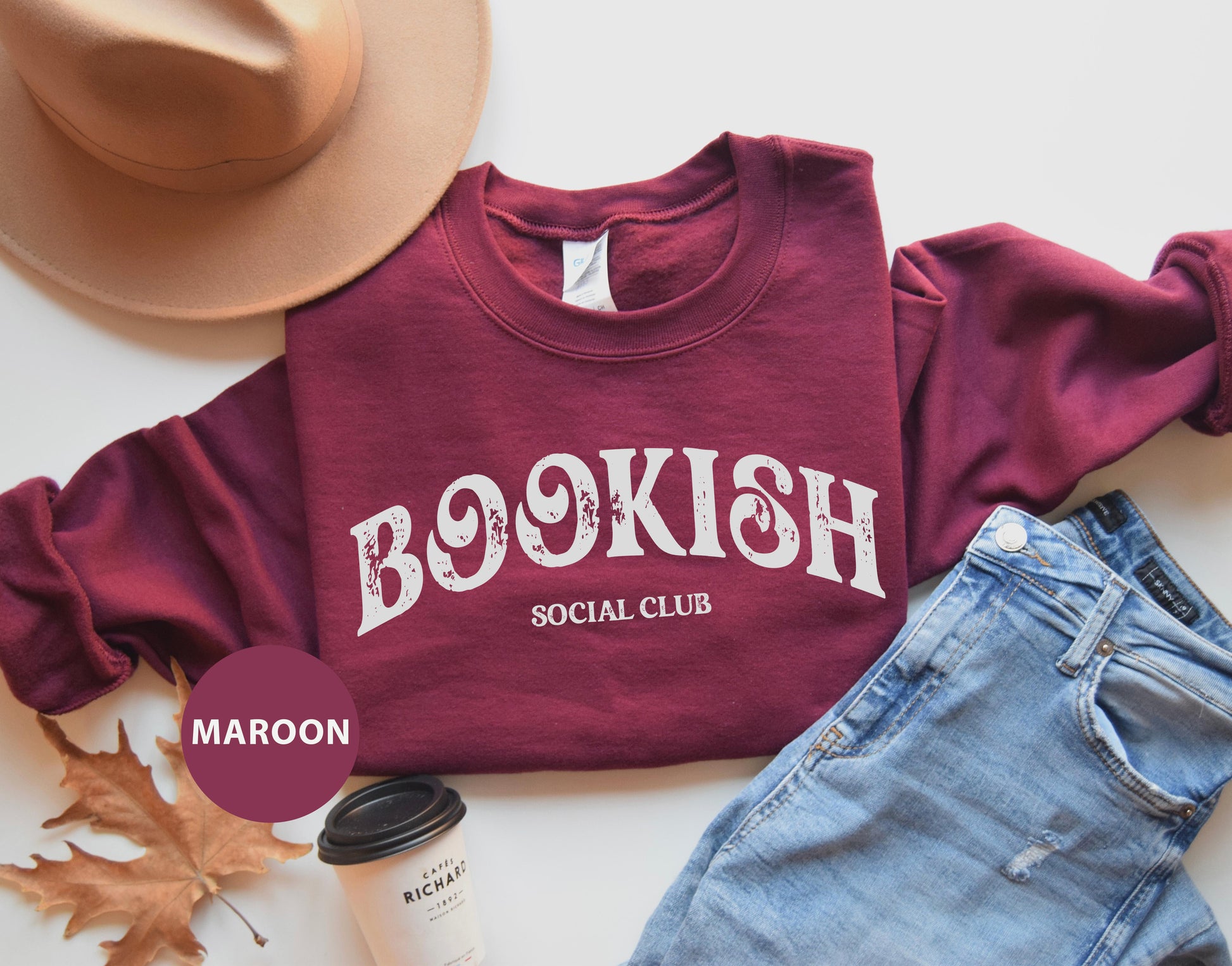 a maroon shirt that says booksh social club next to a pair of jeans and