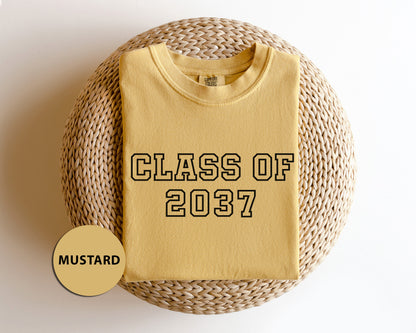 a yellow shirt that says class of 202 next to a wicker basket