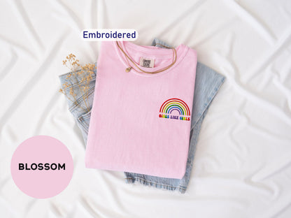 a pink shirt with a rainbow embroidered on it