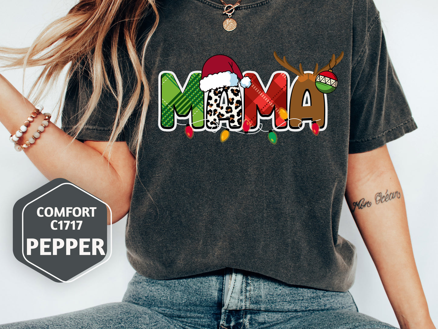 A person wearing a black t-shirt with a colorful graphic design that says "MAMA" and has a Santa hat and reindeer on it.