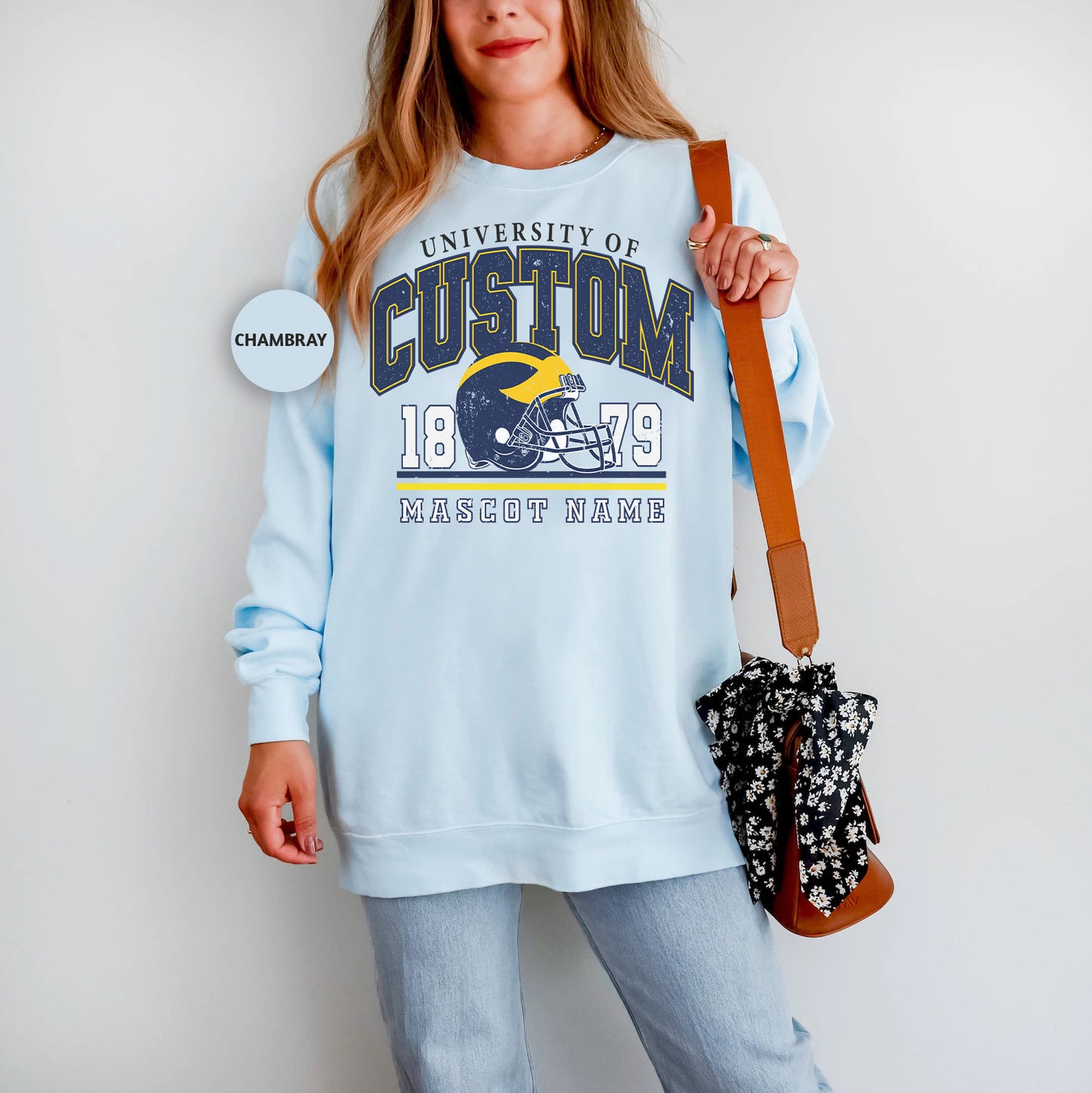 a woman in a blue sweatshirt holding a purse