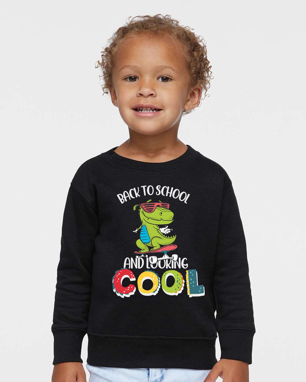 a little boy wearing a black sweatshirt with a dinosaur on it