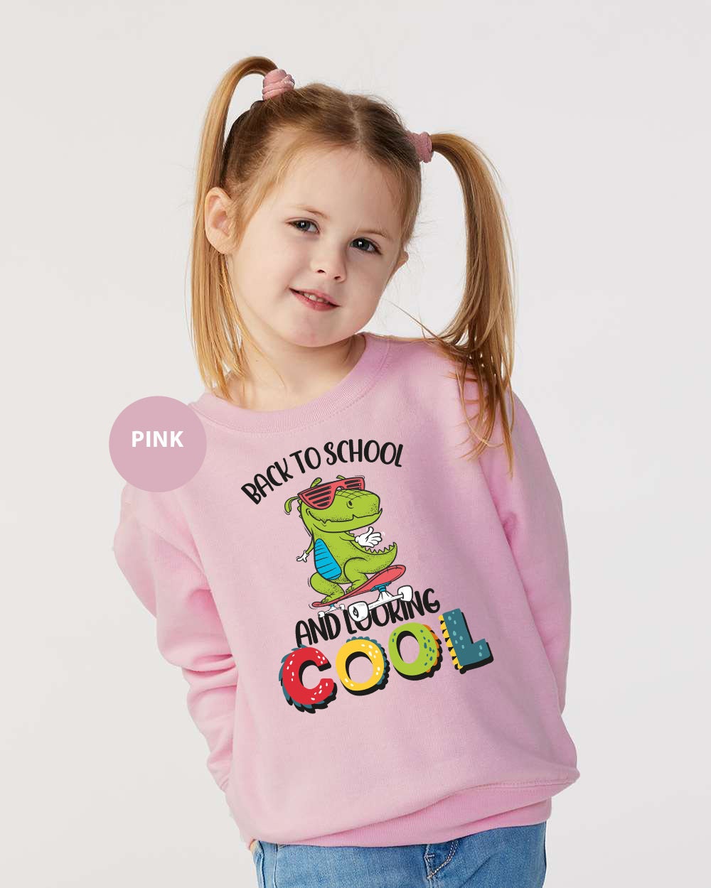 a little girl wearing a pink sweatshirt with the words back to school and croc