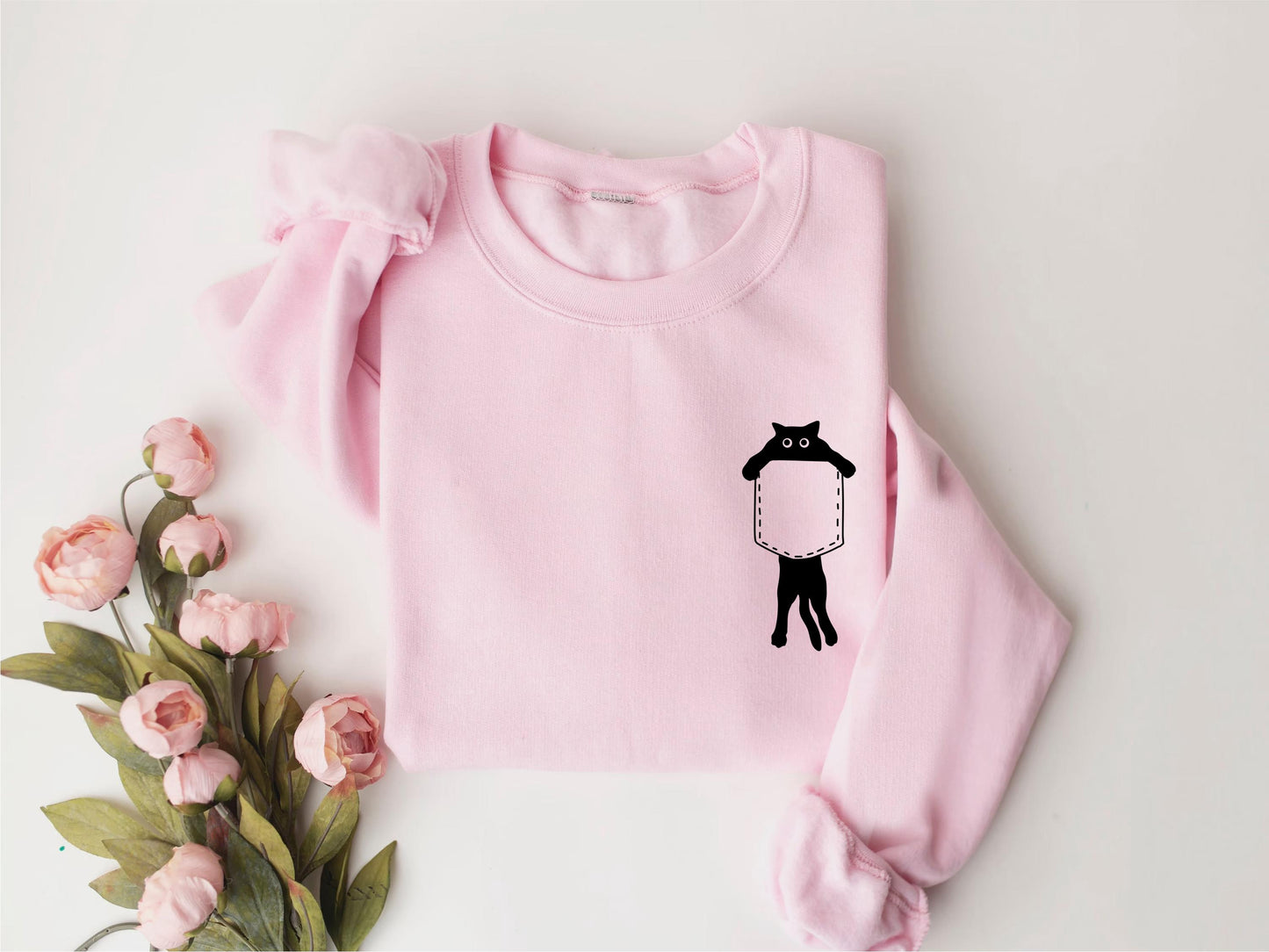 a pink sweater with a black cat on it