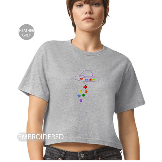 a woman wearing a grey crop top with a flower design on it