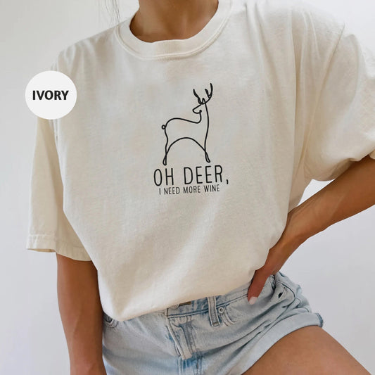 a woman wearing a white shirt that says oh deer, i need more wine