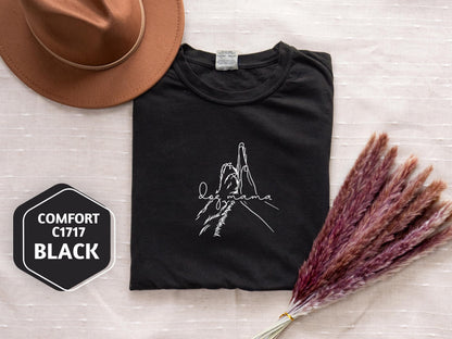 a t - shirt with a picture of a person on it next to a hat