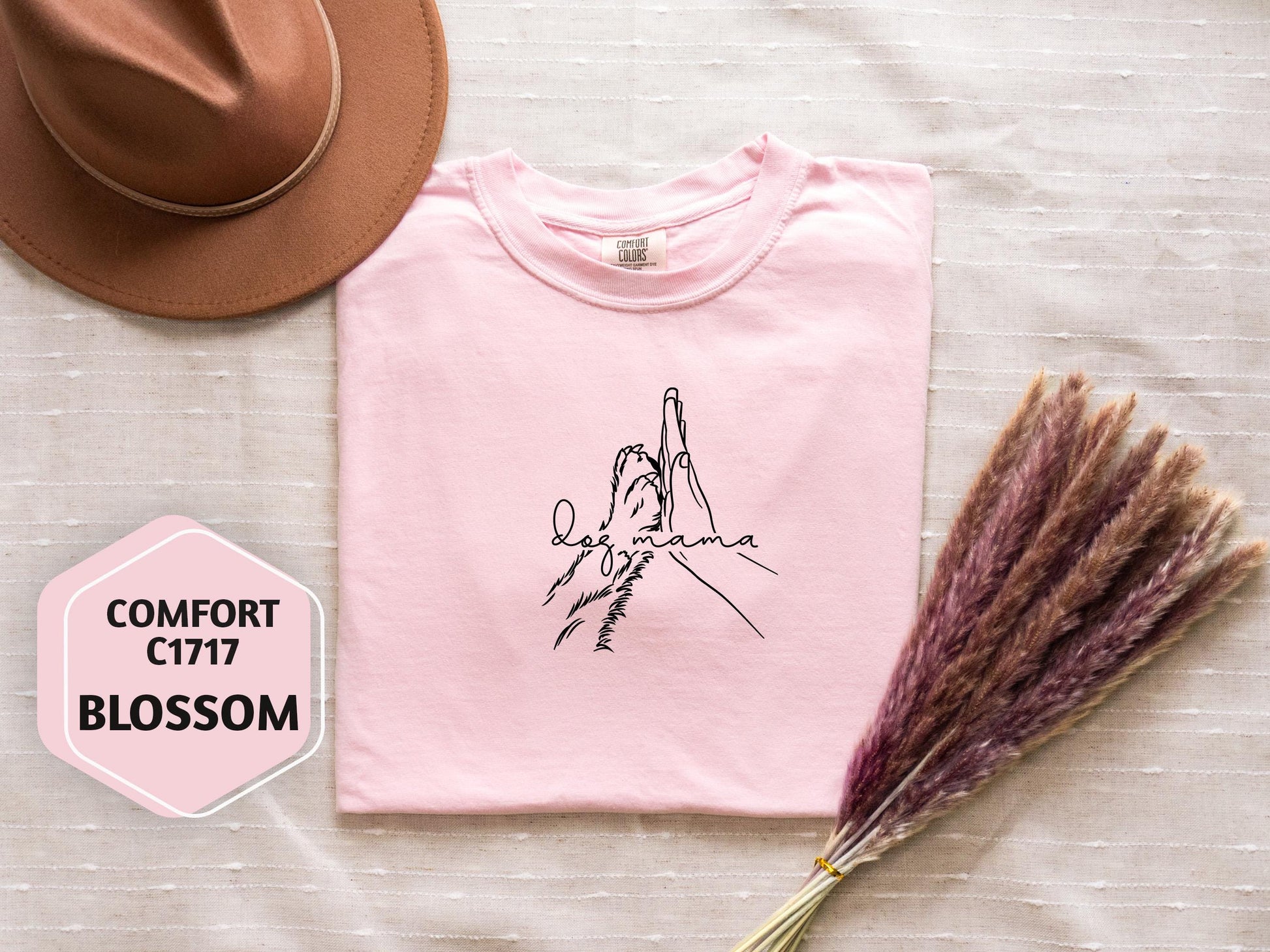 a pink t - shirt with a drawing of a hand holding a cross on it