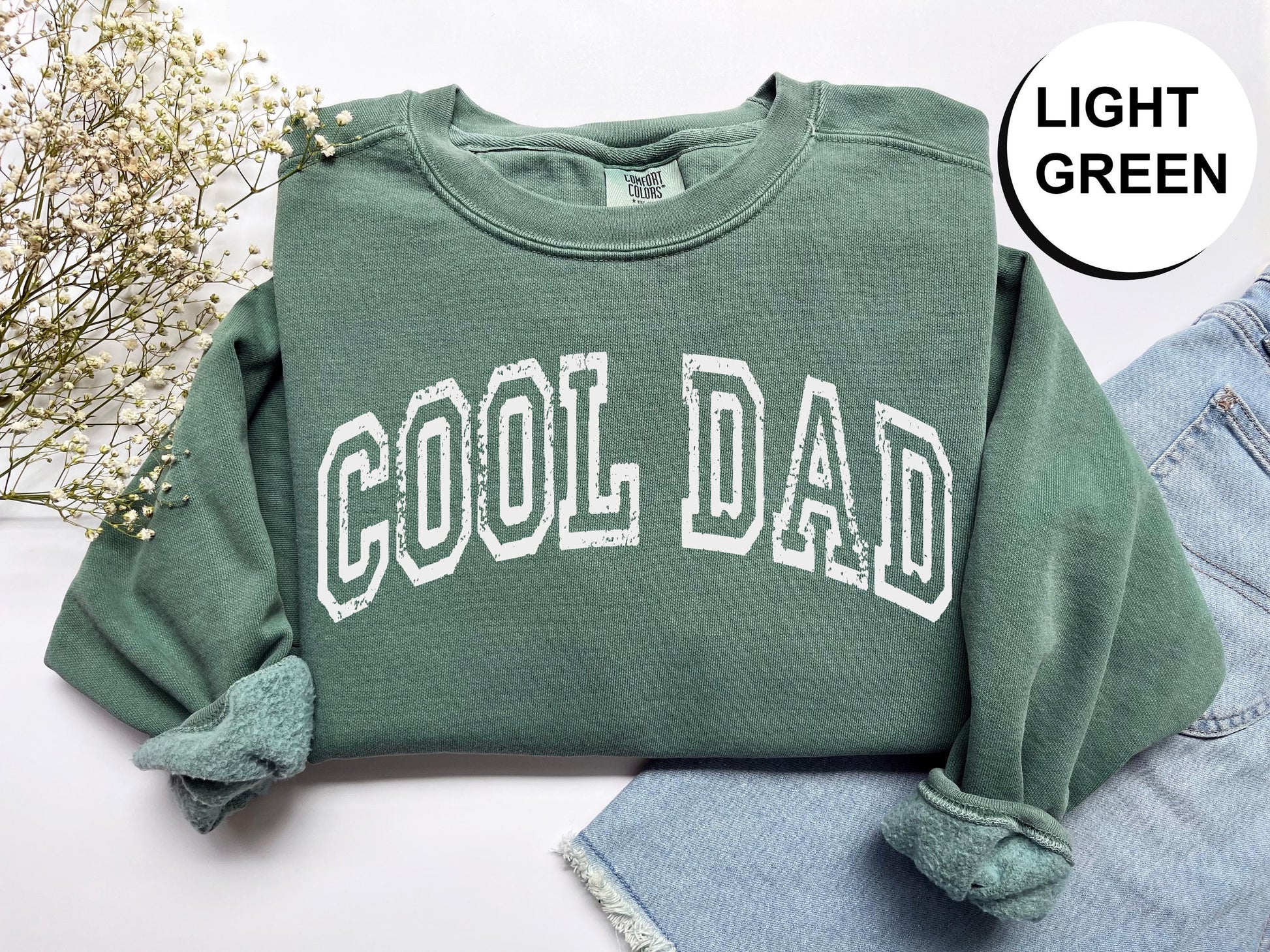 a green sweatshirt with the word cool dad printed on it