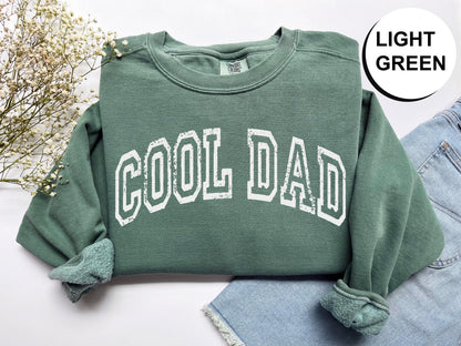 a green sweatshirt with the word cool dad printed on it