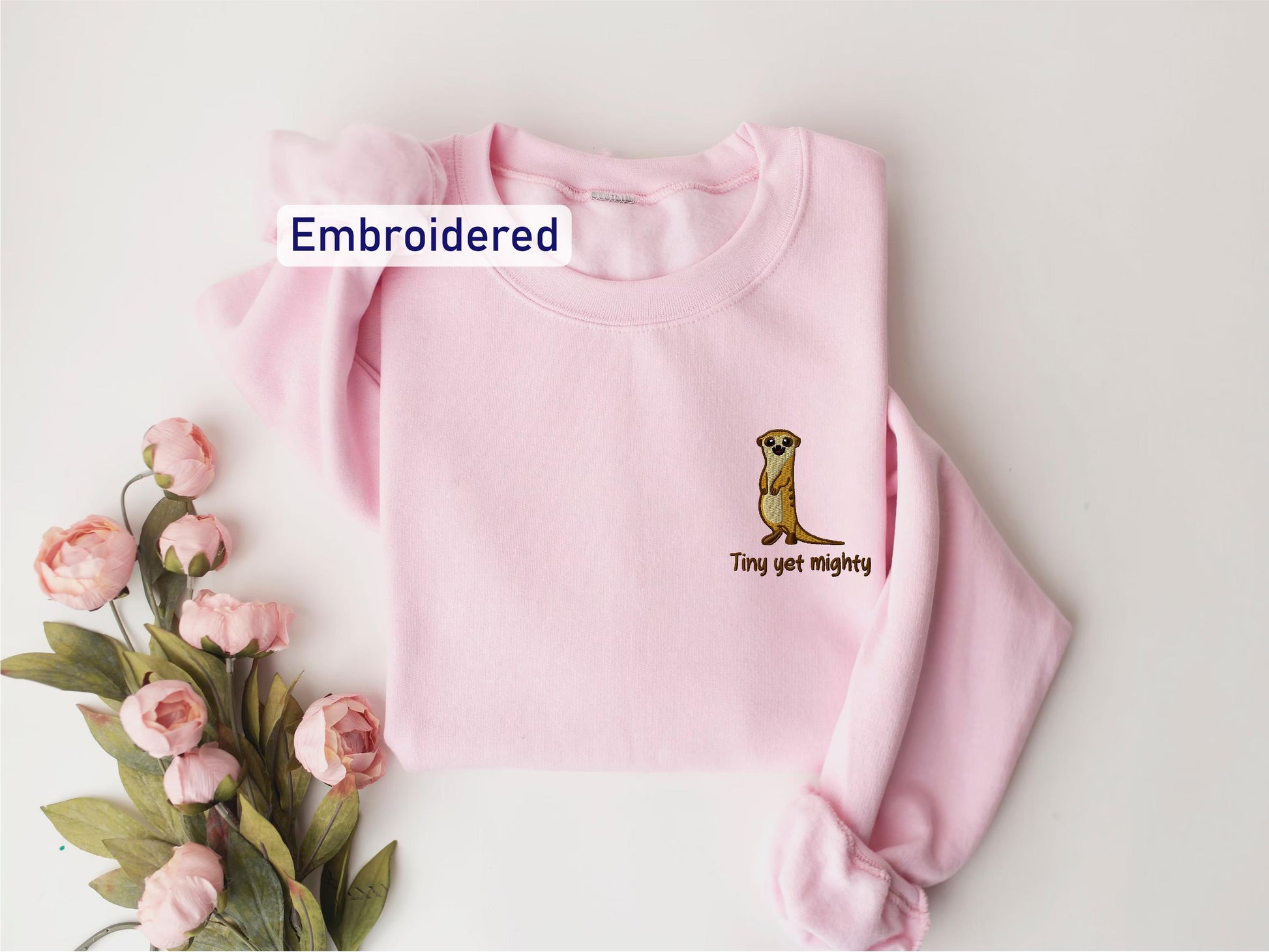 a pink sweater with a kangaroo embroidered on it