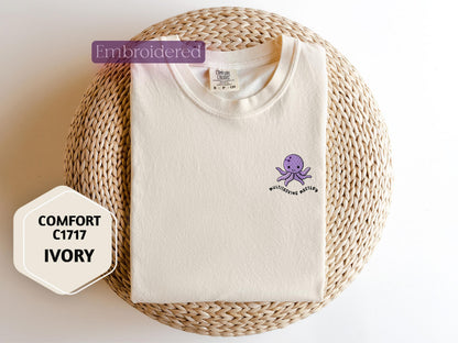 a white shirt with a purple octopus embroidered on it