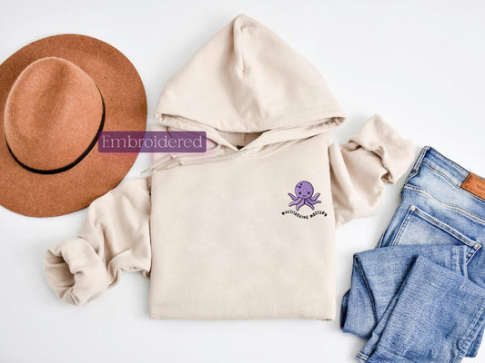 a hat, sweatshirt, jeans, and a hat on a white surface