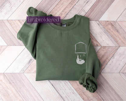 a green sweatshirt with a picture of a man&#39;s head on it