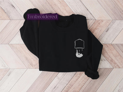 a black sweatshirt with a white outline of a person&#39;s head on it