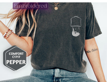 a woman wearing a t - shirt with a picture of a hat on it