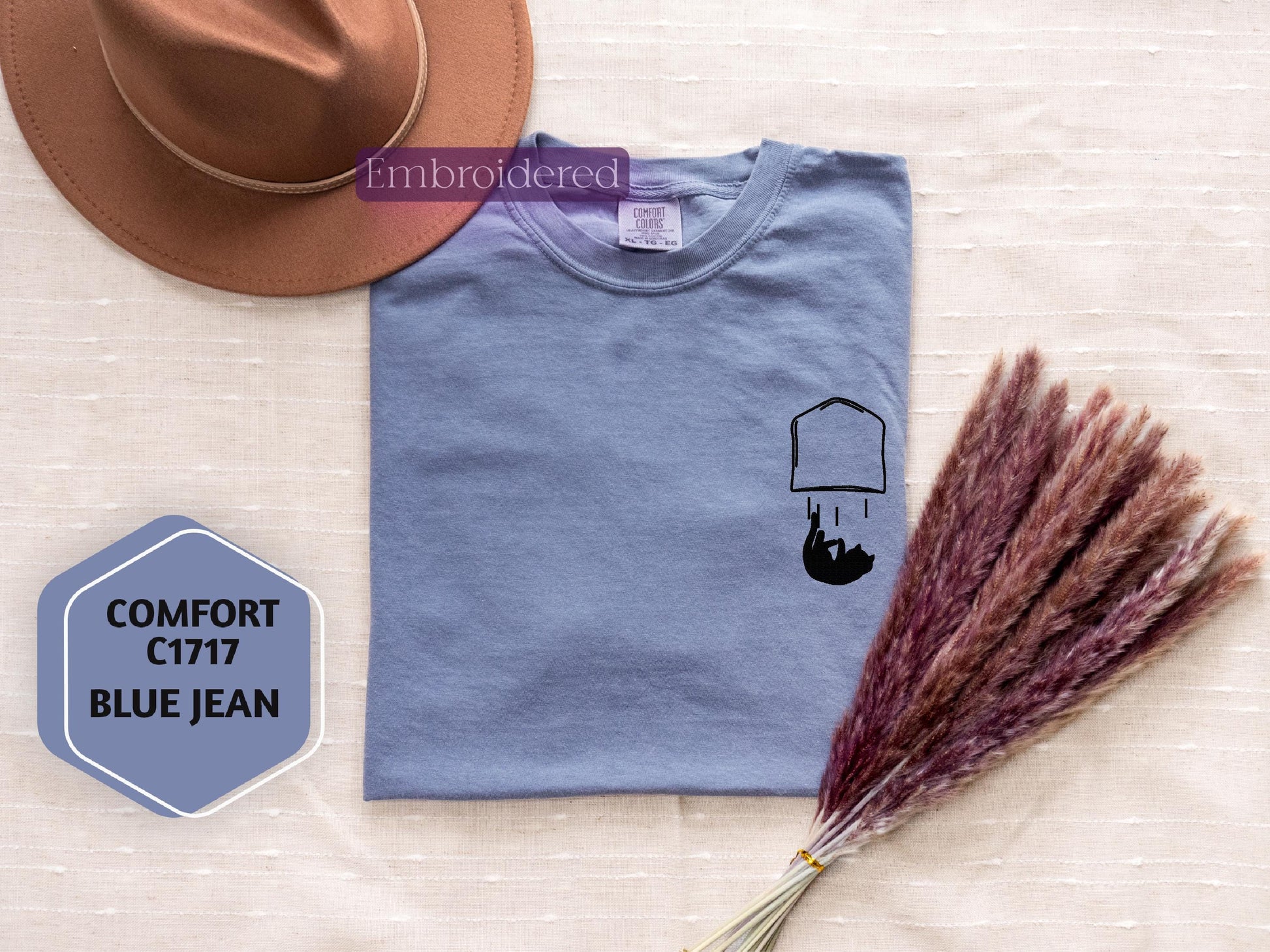 a hat, t - shirt, and a broom on a table