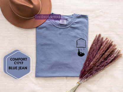 a hat, t - shirt, and a broom on a table