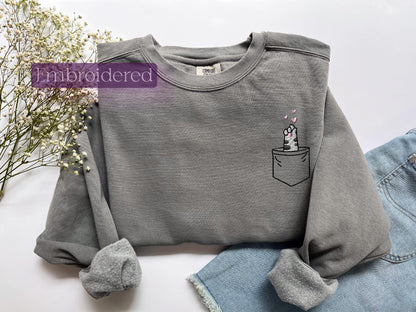 a gray shirt with a unicorn in a pocket on it