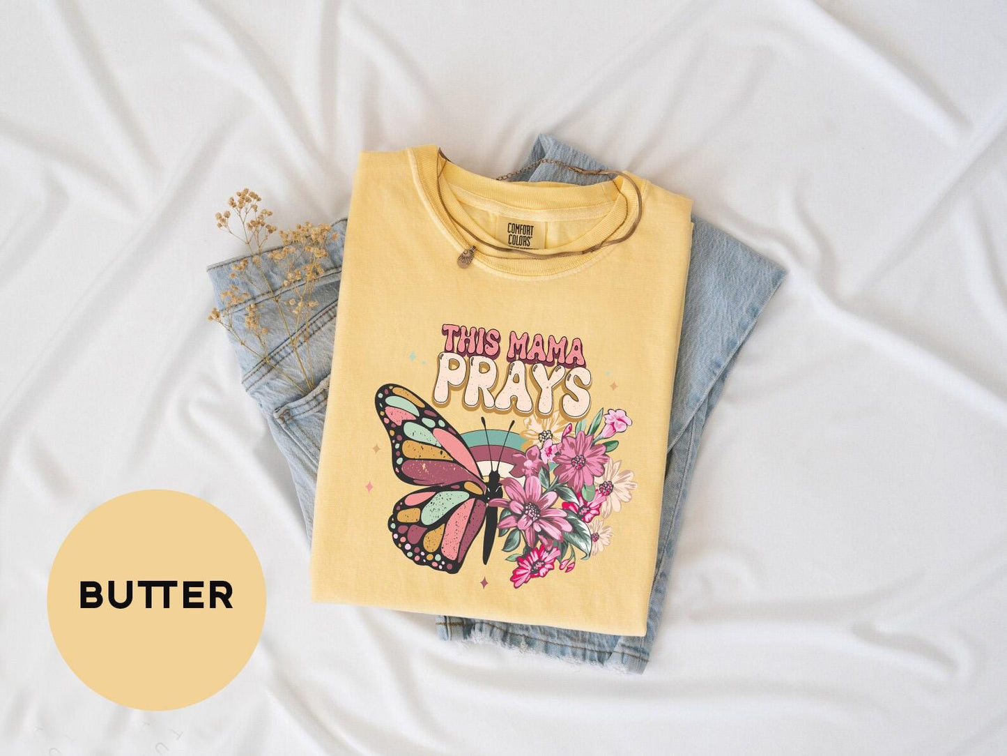 a t - shirt that says, this mama prays with a butterfly on it