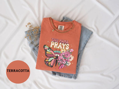 a t - shirt that says, this mama prays with a butterfly on it