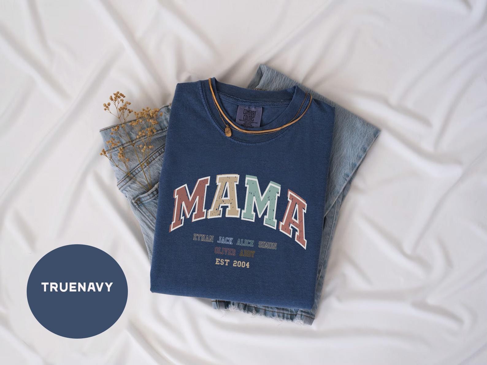 a t - shirt that says mama on it next to a pair of jeans