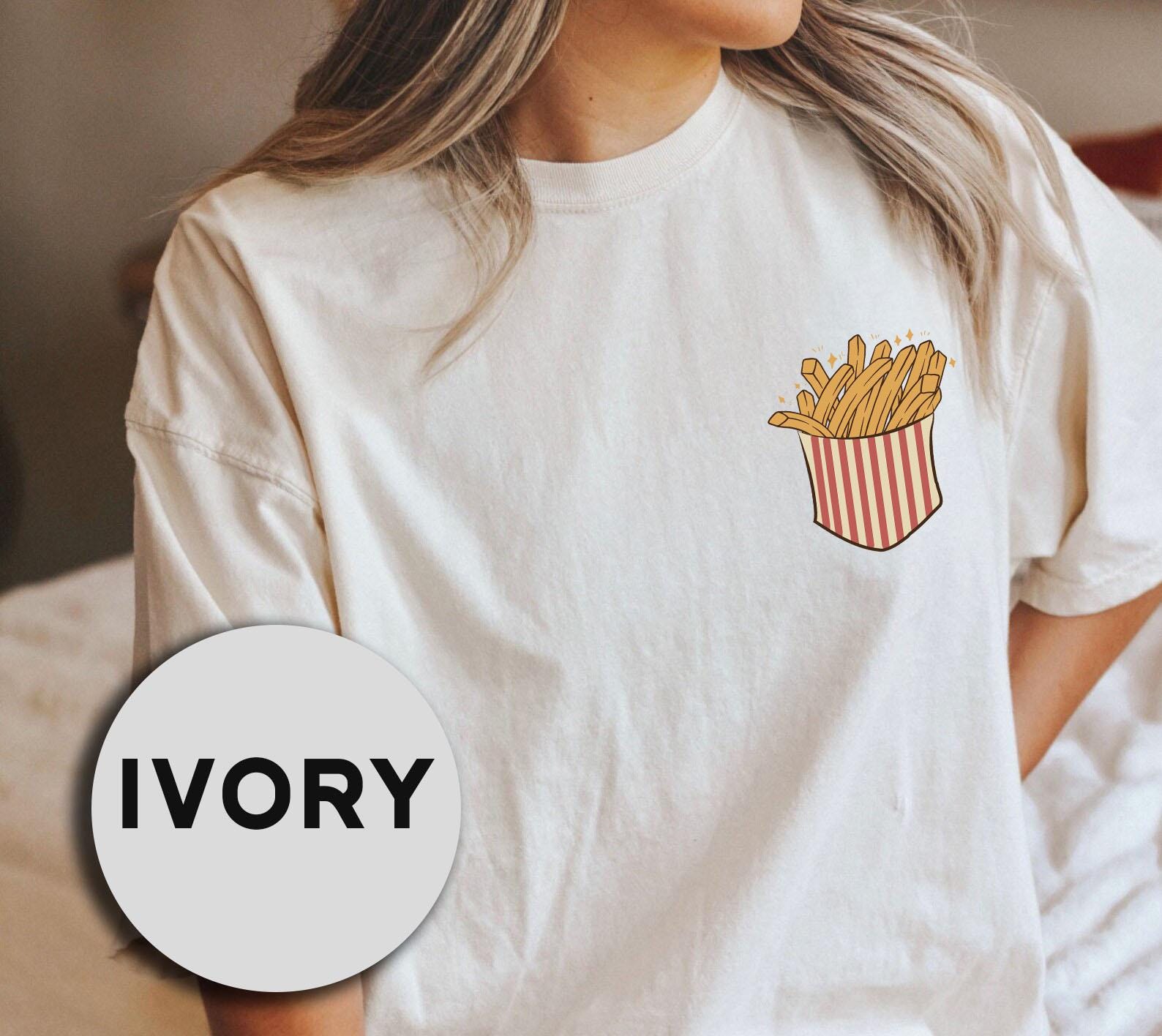 a woman wearing a t - shirt with a french fries pocket on it