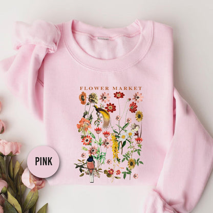 a pink flower market sweatshirt next to pink flowers