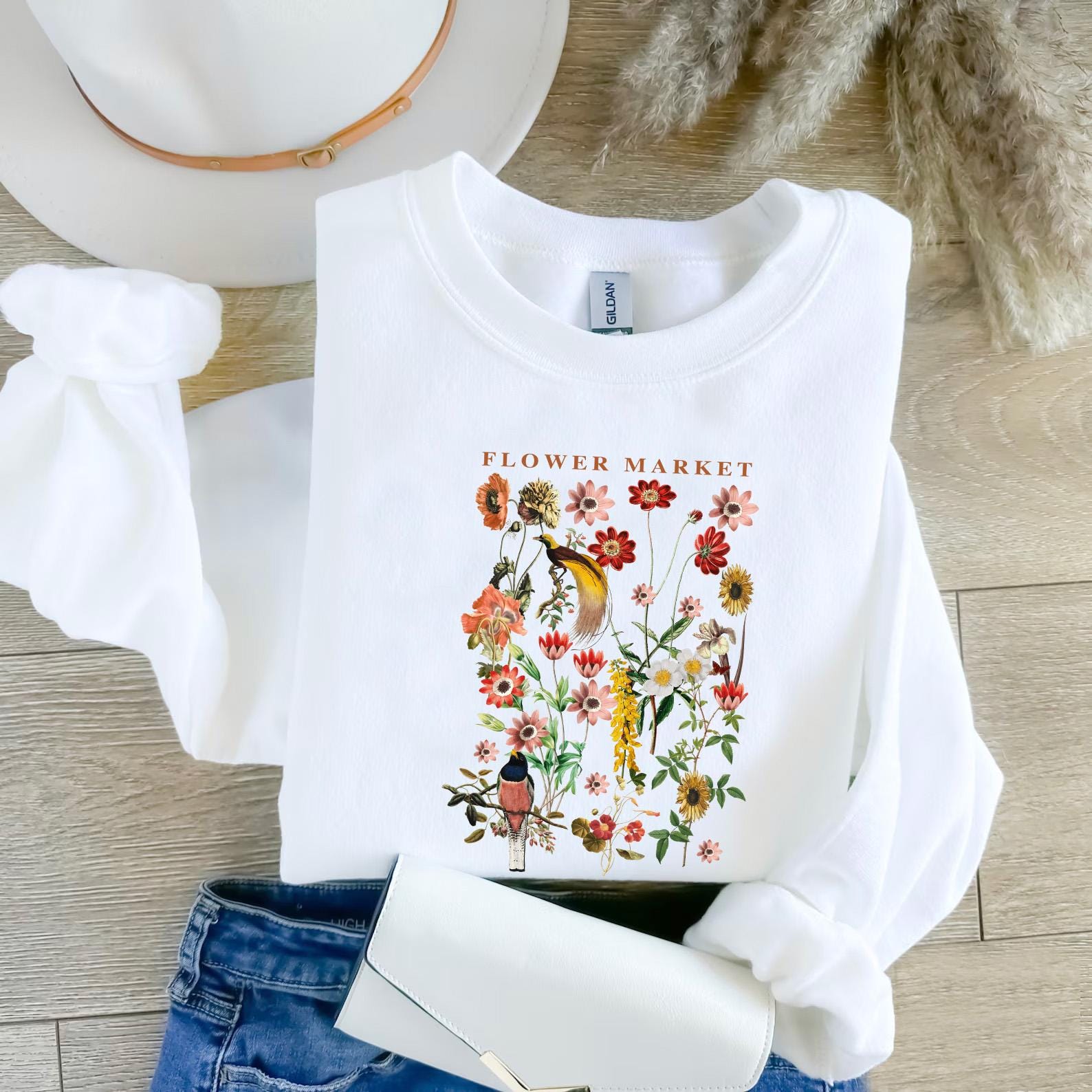 a white t - shirt with a flower market picture on it