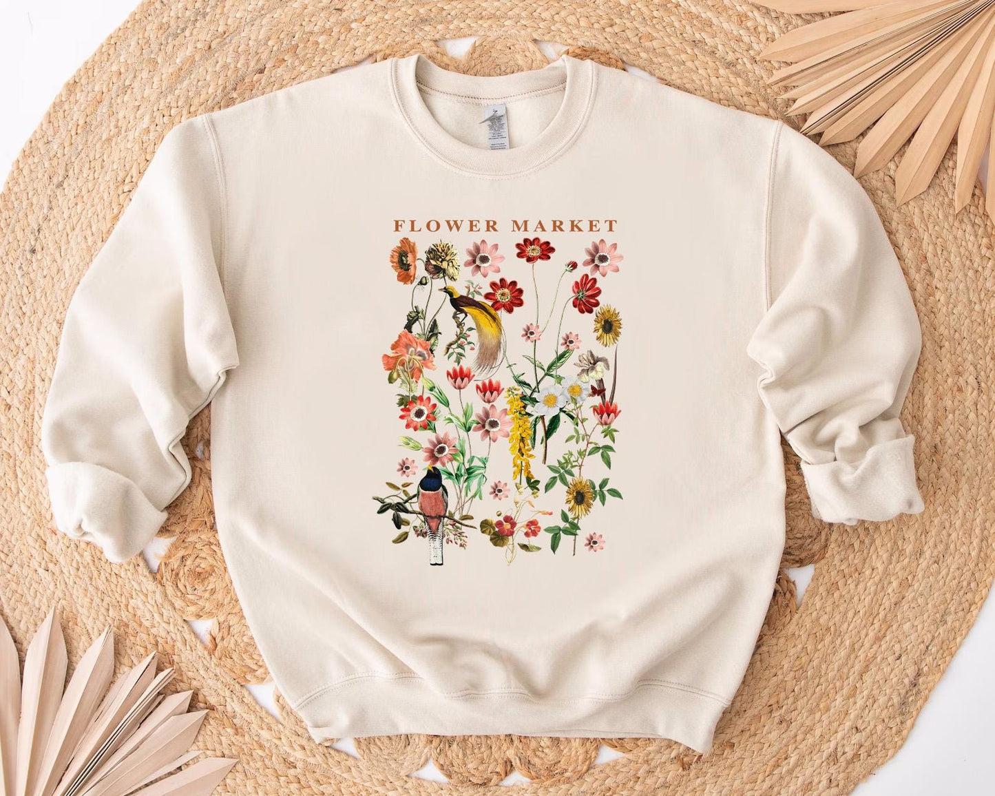 a white sweatshirt with flowers and birds on it